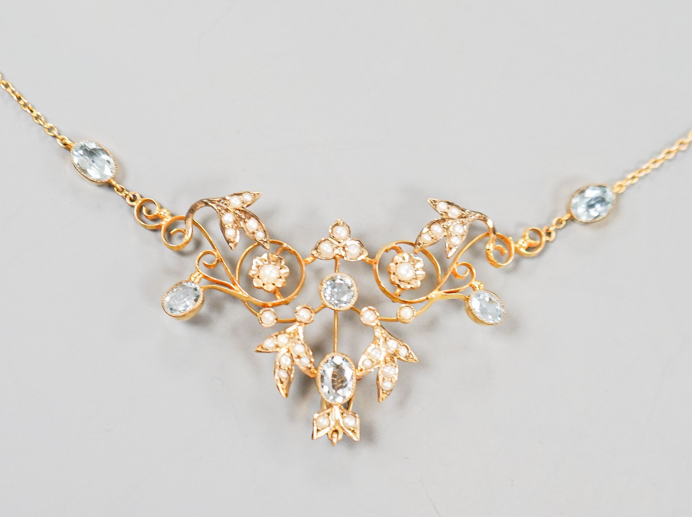 An Edwardian 9ct, aquamarine and seed pearl set drop pendant necklace, 40cm, gross weight 7.2 grams.